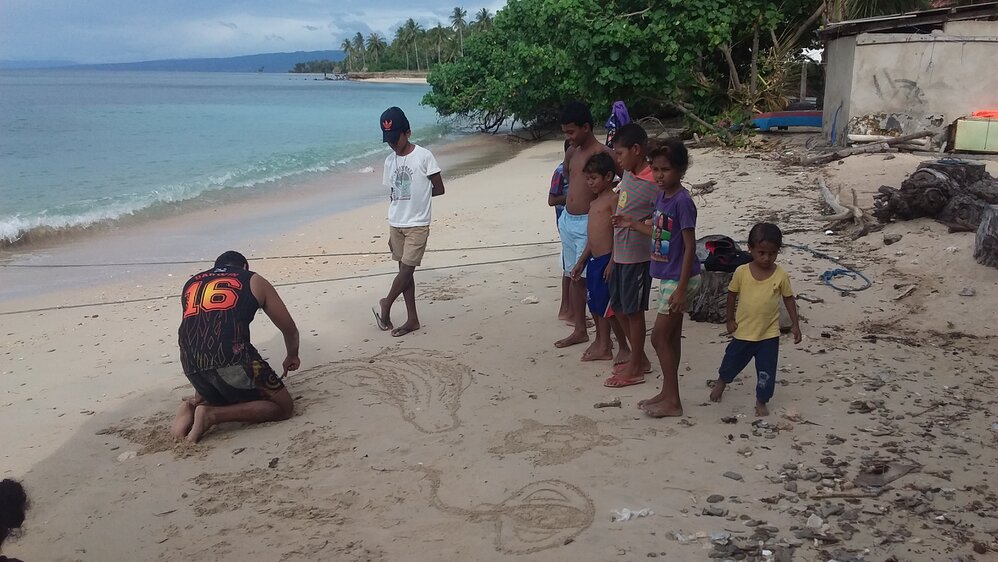 Anthony making sand creations for village kids