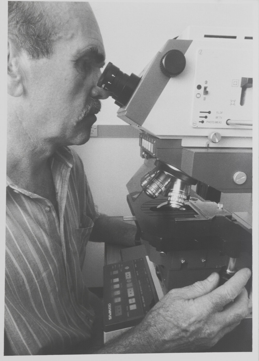 Researcher using microscope