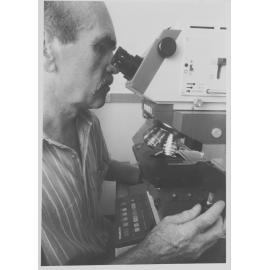 Researcher using microscope